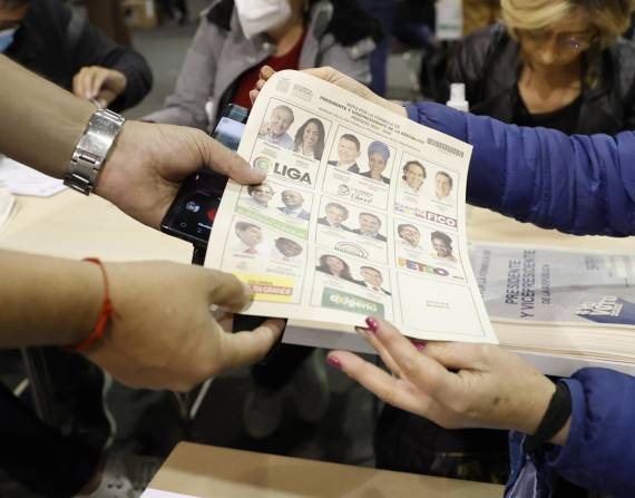 Un hombre recibe una tarjeta electoral hoy, durante la jornada de elecciones para elegir presidente de Colombia para el periodo 2022-2026.