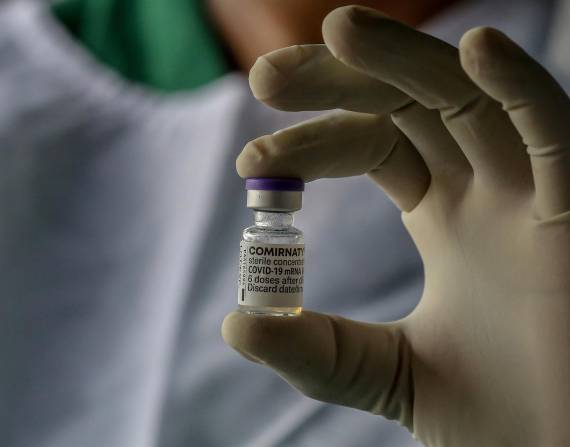 Un enfermero muerta una vial de la vacuna.