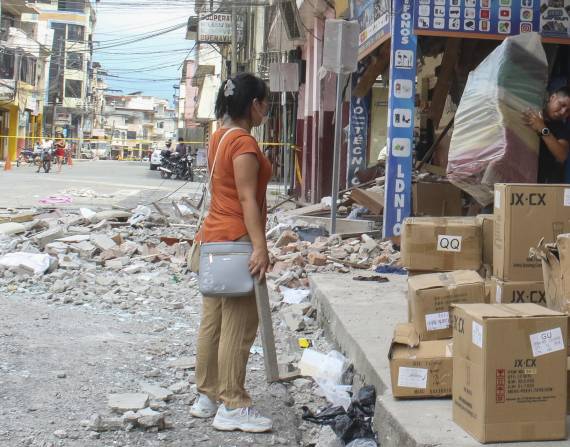 Comerciantes retiran mercancías de una edificación afectada por un terremoto de magnitud 6,5 en la ciudad de Pasaje, El Oro.