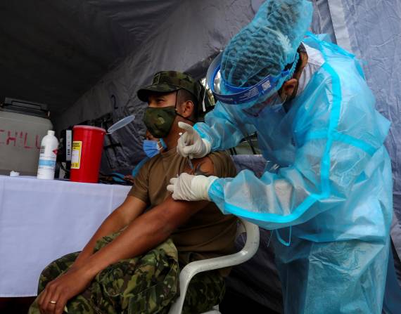 Fotografía de archivo en la que se registró a un militar ecuatoriano al ser vacunado contra el covid-19, en el fuerte militar Epiclachima, en Quito (Ecuador).
