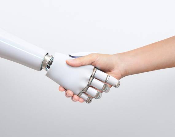 Una imagen que muestra a una mano robot y humana estrechando lazos.
