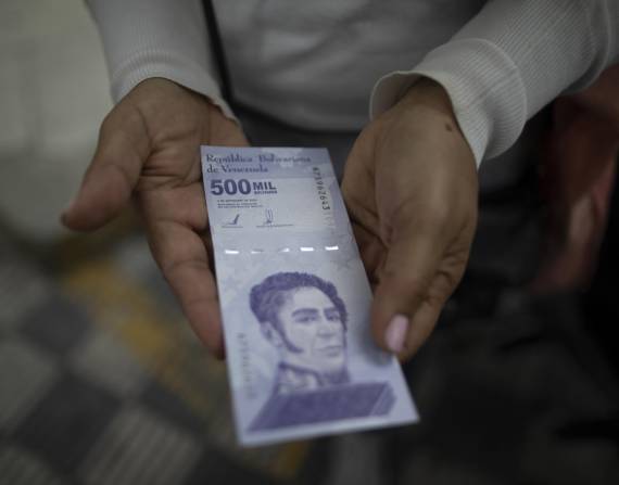 Una mujer muestra un billete de 500.000 bolívares luego de retirarlo de un banco en Caracas, Venezuela.