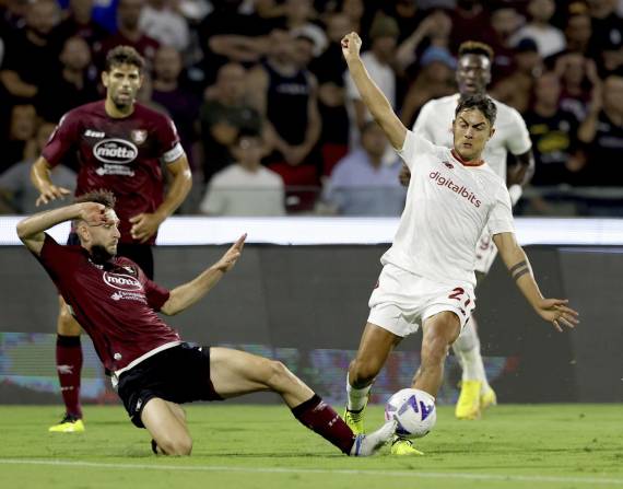 Paulo Dybala (derecha) de la Roma pugna el balón con un rival de Salernitana en el partido de la Serie A italiana, el domingo 14 de agosto de 2022. (Alessandro Garofalo/LaPresse vía AP)