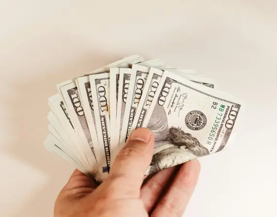 Imagen de una persona sosteniendo un fajo de billetes.