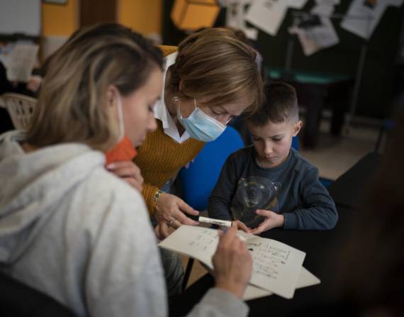 Carmen, una residente de Cataluña, enseña catalán a los refugiados ucranianos Tetiana Horobii y su hijo Maxym Batrak en Guissona, España, el 22 de marzo del 2022.