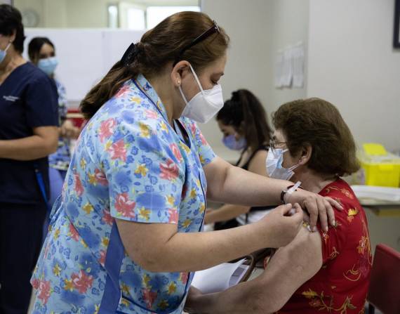 Una persona recibe una dosis de la vacuna contra la covid-19, hoy, en un centro de vacunación de Santiago.