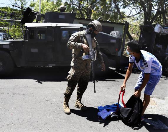 Un soldado revisa la mochila de un hombre a la salida de la Comunidad Las Palmas