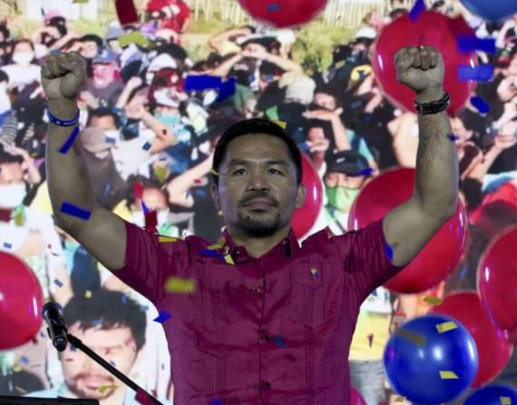 Pacquiao alza las manos durante la convención nacional de su partido en Quezón, Filipinas.
