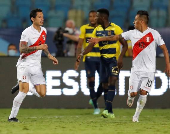 Jugadores de Perú celebran un tanto contra Ecuador.