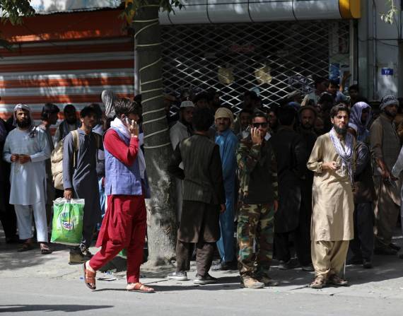 Afganos hacen largas filas el domingo 15 de agosto de 2021 para retirar dinero de un banco, en Kabul, Afganistán.