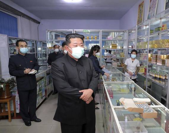 En esta imagen proporcionada por el gobierno norcoreano, el líder de Corea del Norte, Kim Jong Un, en el centro, visita una farmacia en Pyongyang, el 15 de mayo de 2022.