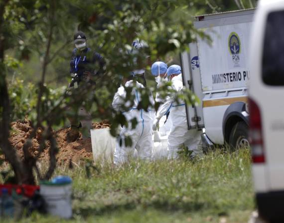 Trabajadores forenses bajan de los vehículos los cuerpos de migrantes fallecidos durante un accidente en autobús el pasado mes de febrero, en David (Panamá).