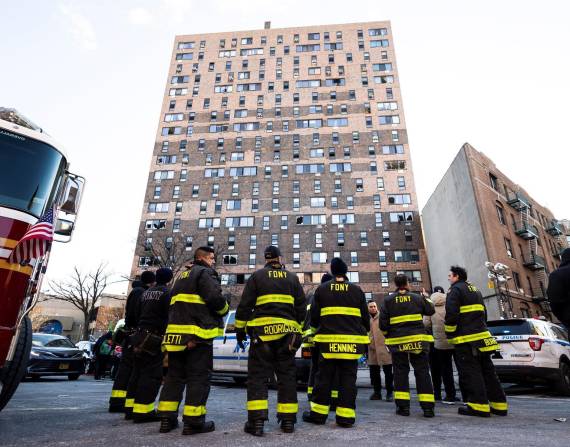 Bomberos de la ciudad de Nueva York observan el edificio de apartamentos que fue el escenario de un incendio en el Bronx.