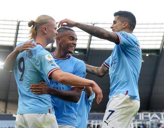 Erling Haaland (i) festeja un gol junto a Manuel Akanji (c) y Joao Cancelo durante el encuentro ante el Brighton por Premier League.