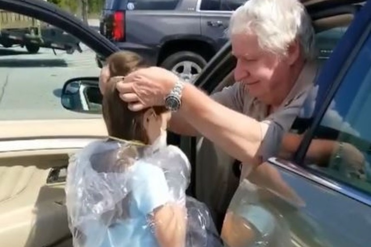 Abuelo ayuda a su nieta para que pueda abrazar a su padre