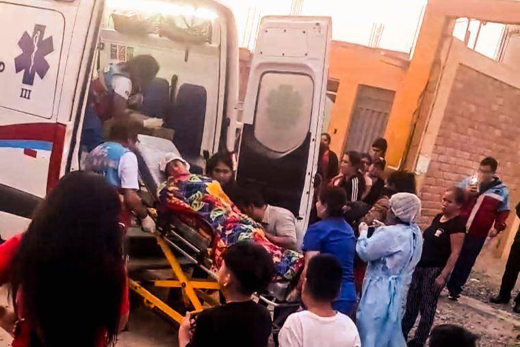 Un niño siendo trasladado al hospital por ser herido por las balas en el evento la Chocolatada, en Perú.