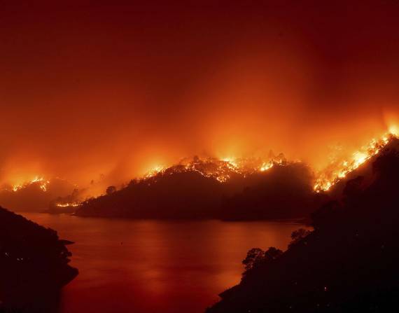 Unos miembros del Departamento Forestal y de Protección contra Incendios de California supervisan un operativo contra incendios, mientras las llamas arrasan con el bosque nacional de Lassen, el lunes 26 de julio de 2021.