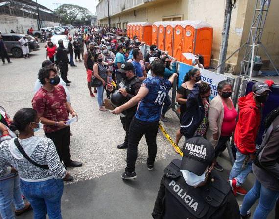 Centenas de personas esperaron afuera del mercado la Causarina en el noroeste de Guayaquil para ser vacunados.