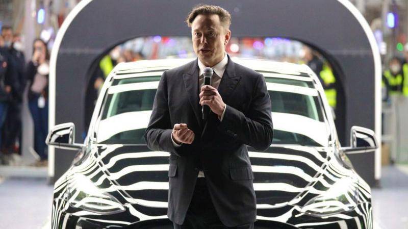 Elon Musk junto a un auto Tesla