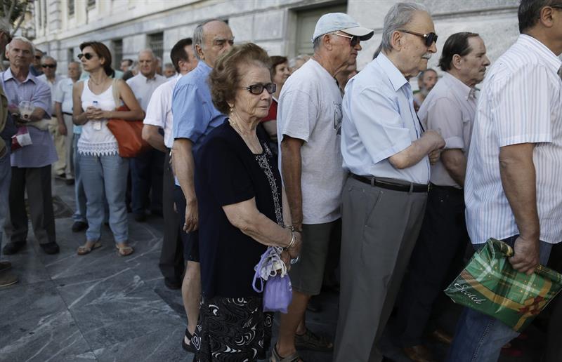 Grecia paga deuda, reabre sus bancos y aumenta el IVA