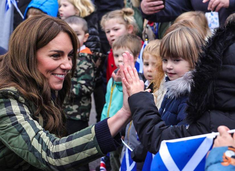 Kate Middleton chocando su mano a un niño