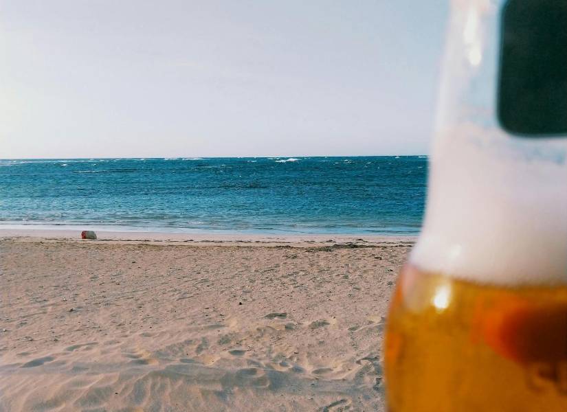 Botella de vidrio de cerveza en la playa