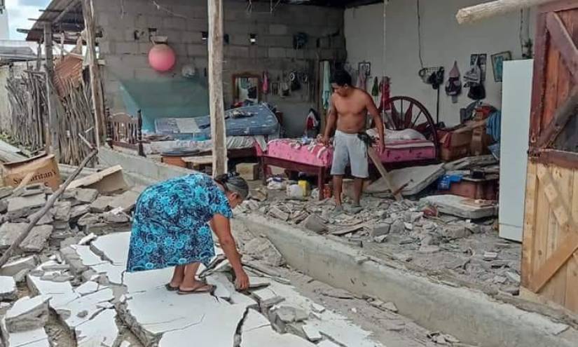 Una mujer recoge los pedazos de una pared desplomada de su casa en la isla Puná.