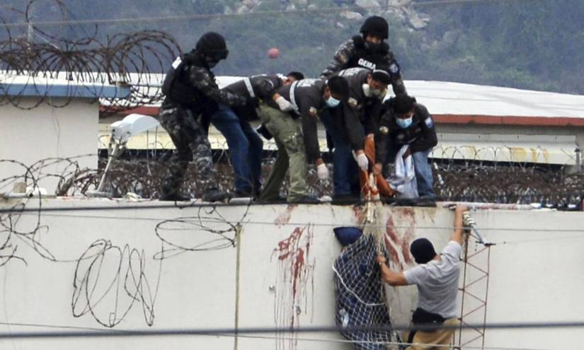 La policía baja el cuerpo de un preso desde el techo de la Penitenciaría del Litoral.