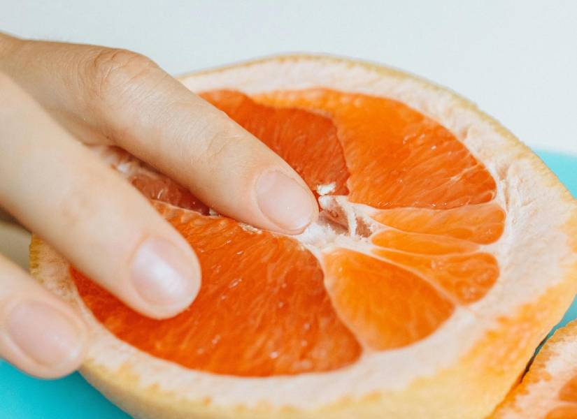 Dedo en una mandarina, simbolizando el placer en la mujer