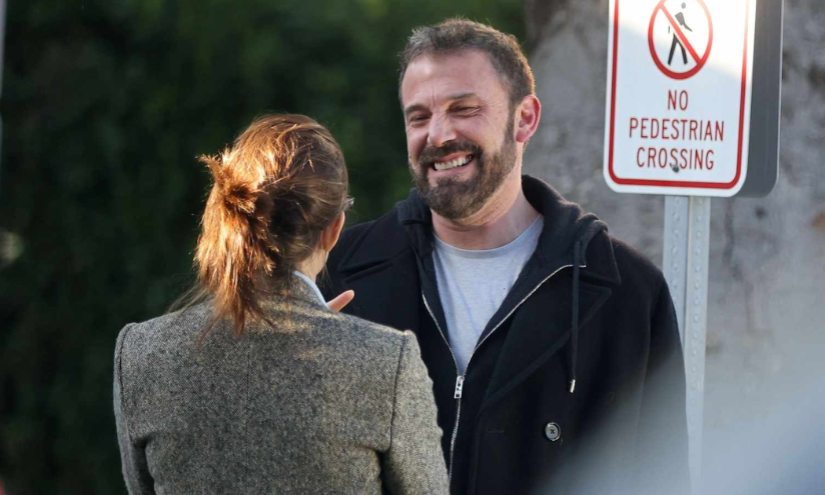 Jennifer López y Ben Affleck riéndose mientras conversan.