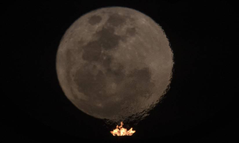 Fotografía de la superluna del ciervo a través del fuego que se enciende en el Panteón de la Patria y la Libertad, hoy en Brasilia (Brasil).
