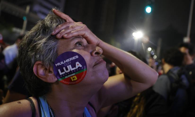 Simpatizantes del expresidente y candidato presidencial, Luiz Inácio Lula da Silva, observan cómo avanzan los resultados, en una plaza de Sao Paulo.
