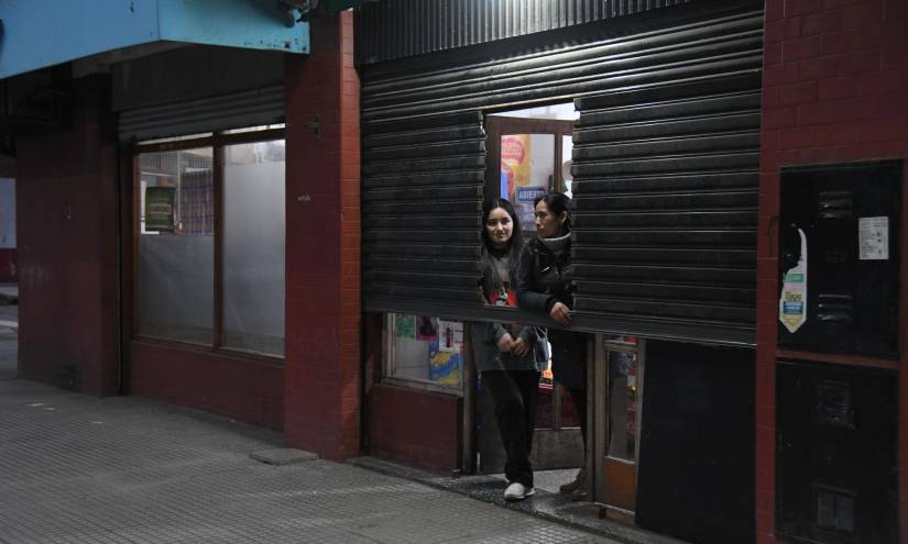 Dos mujeres fueron registradas al asomarse en la entrada de un negocio a medio abrir, debido a la ola de inseguridad en Buenos Aires, Argentina