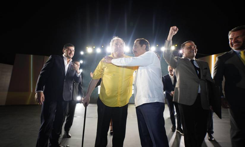 Momento exacto en que los políticos, Abdalá Bucaram y Jaime Nebot, se saludan con un abrazo cordial en un evento de Barcelona SC.