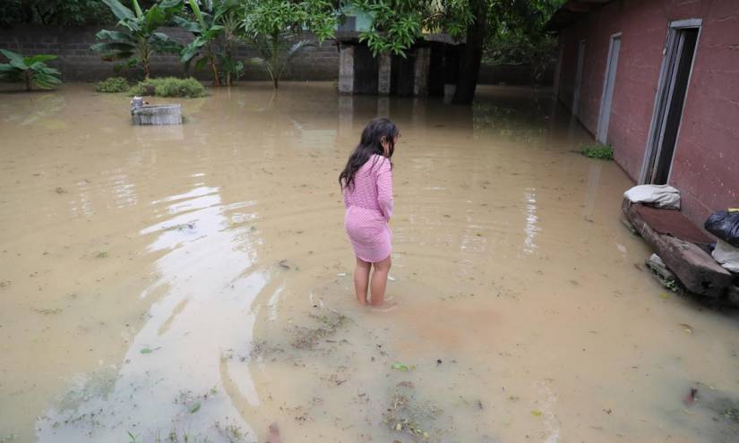 Una niña permanece afuera de su casa inundada, en la ciudad del Progreso, Honduras.