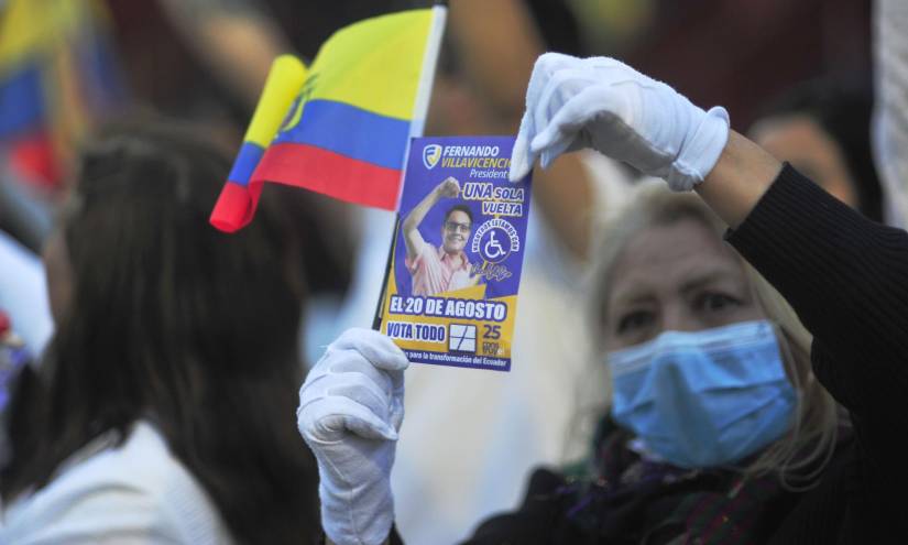 Imagen de una señora sosteniendo una imagen de Fernando Villavicencio, en un plantón por su asesinato.