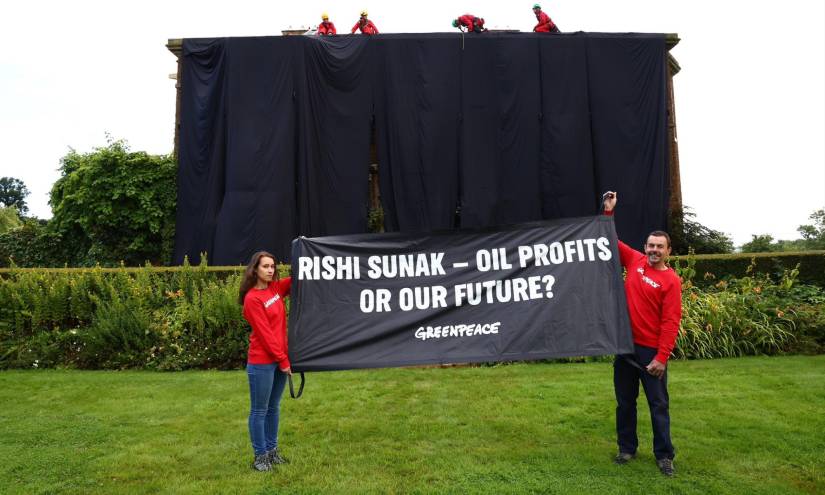 El grupo de ambientalistas posando frente a la casa cubierta de negro del primer ministro británico.