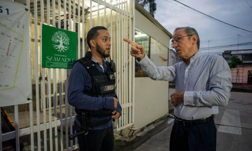 Un guardia de seguridad conversa con un residente mientras custodia las calles de un barrio el 6 de julio de 2023, en la ciudad de Guayaquil (Ecuador)