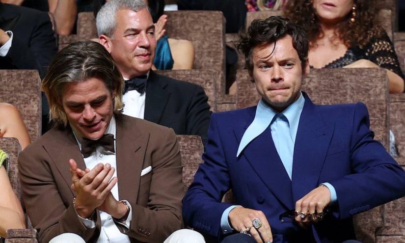 Chris Pine y Harry Styles sentados uno alado del otro en la premiere en el Festival de Venecia.