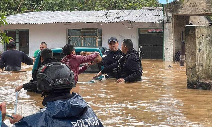 Fotografía cedida por la Secretaría de Seguridad Estatal donde se observa a policías estatales rescatando personas en un área inundada hoy, en el municipio de Xalapa, en el estado de Veracruz (México).