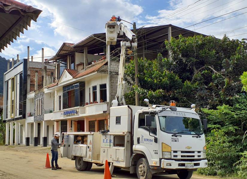 Un técnico realiza una revisión en un poste de alumbrado eléctrico.