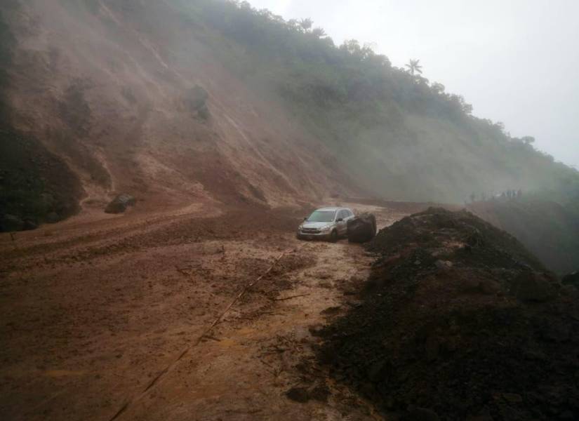 Imagen de un vehículo atrapado en un deslizamiento de tierra en una vía de Azuay.