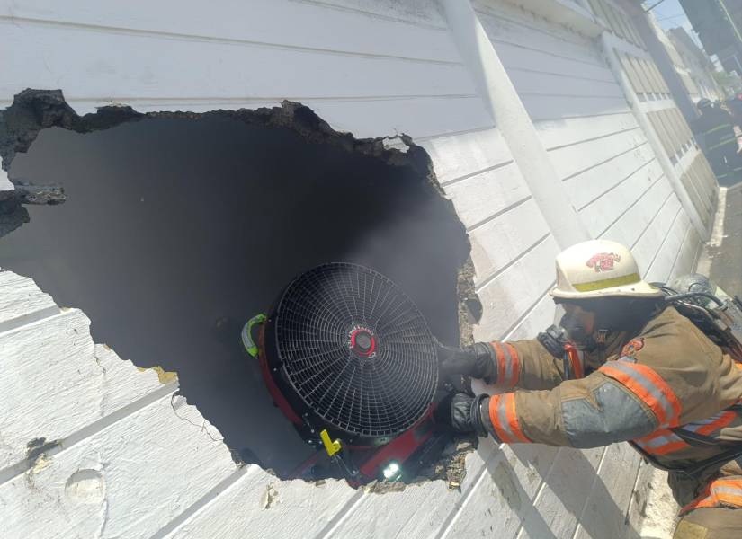 Imagen de bomberos apagando un incendio en el interior de una bodega del sur de Guayaquil, este 11 de septiembre.