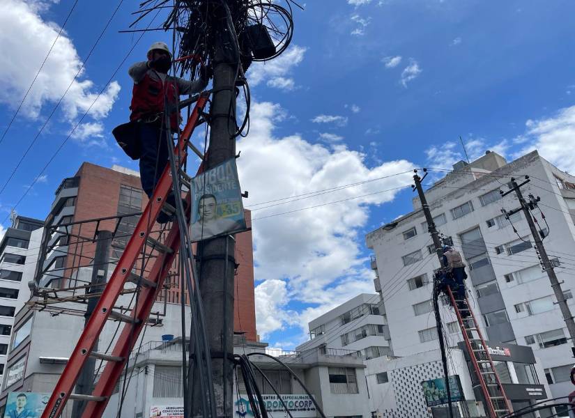 Los obreros de Epmmop cortando los cables en la av. Diego de Almagro.
