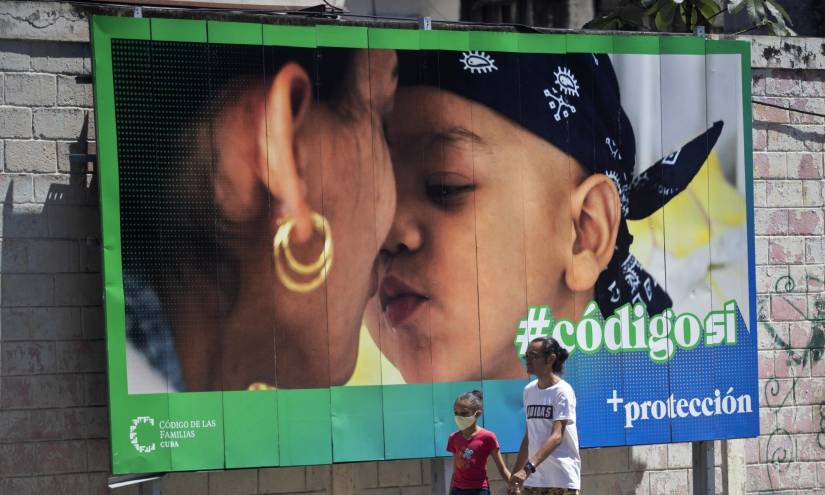 Un hombre y su hija pasan caminando frente a una valla que hace parte de la campaña por el SÍ en el referendo sobre el código de familia, hoy en La Habana (CUBA).