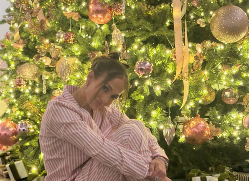 Jennifer López en pijama junto al árbol de navidad.