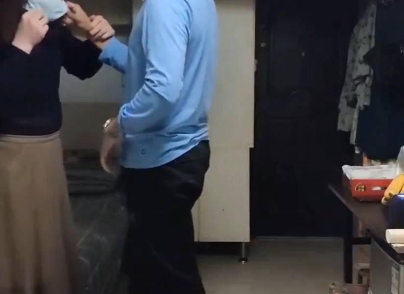 Sister Hong junto a un hombre en una habitación.