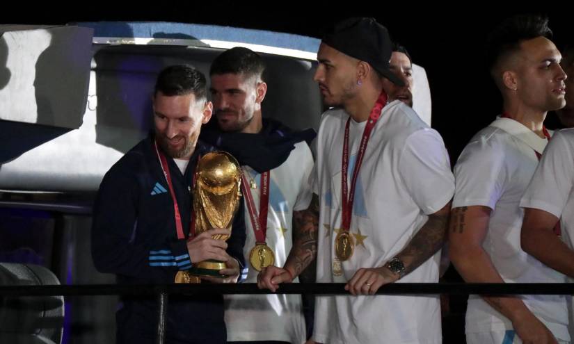 Lionel Messi (i) de la selección argentina de fútbol sostiene el trofeo del Mundial de Fútbol Qatar 2022 junto a Rodrigo de Paul (c) a su llegada hoy, al Aeropuerto Internacional de Ezeiza a unos 22km de Buenos Aires (Argentina).