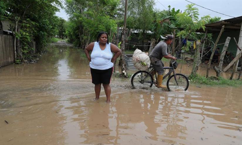 Residentes transitan una calle inundada hoy, en la Colonia Jehová Jireth del municipio de San Manuel, departamento de Corte, Honduras.