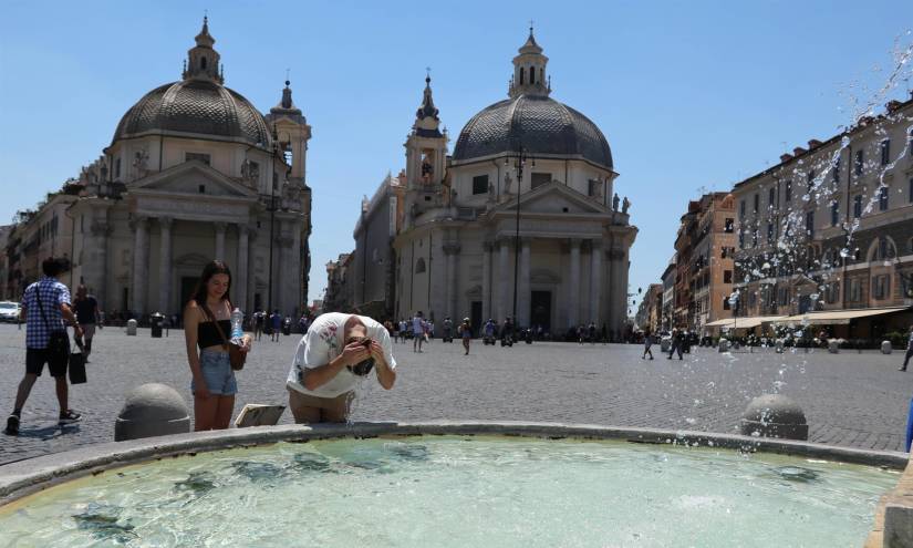 Un hombre se refresca en una fuente en Italia por las altas temperaturas.